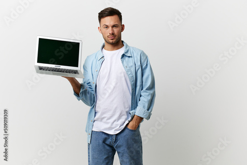 Cheerful friendly tanned handsome IT professional man in casual basic t-shirt with laptop on hand posing isolated on over white studio background. Copy space Banner Mockup. Electronics repair concept