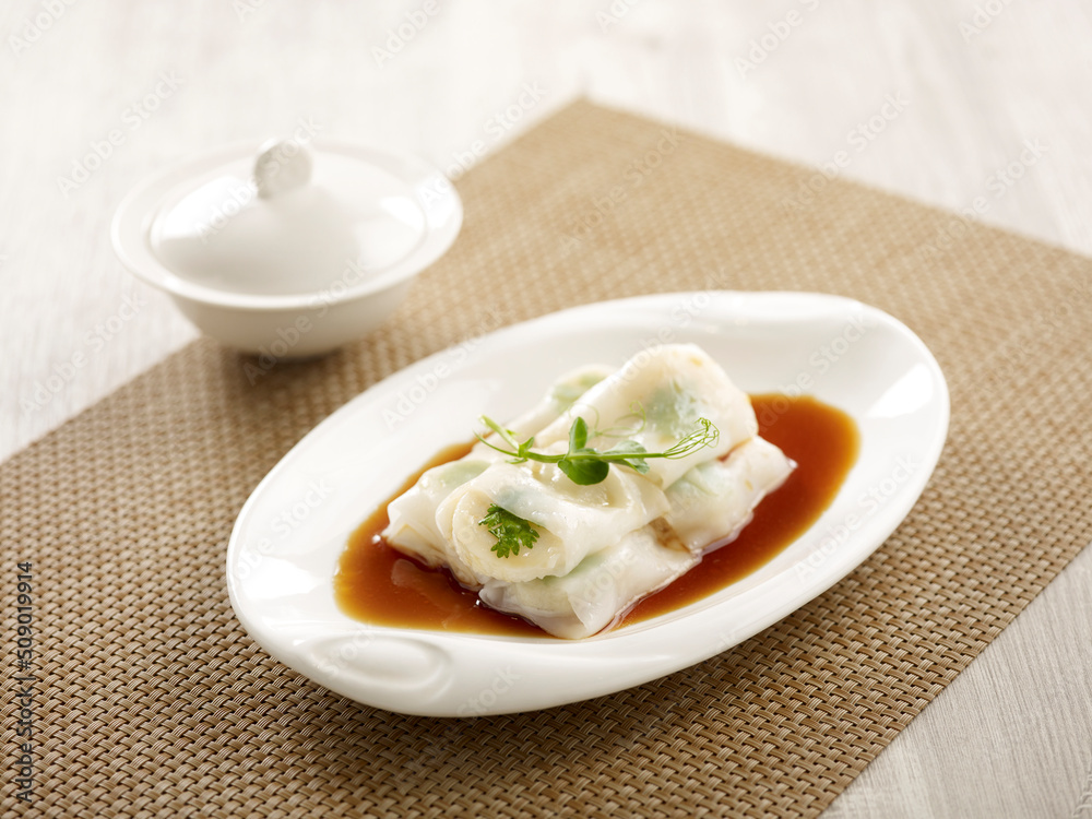 Steamed Cheong-fun with Scallop Filling and bechamel sauce served in a dish side view on grey marble background Steamed Cheong-fun with Scallop Filling and bechamel sauce served in a dish side view on grey marble background
