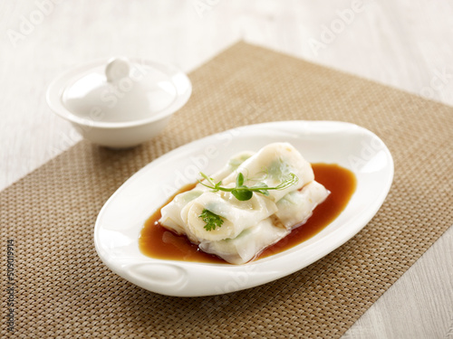 Steamed Cheong-fun with Scallop Filling and bechamel sauce served in a dish side view on grey marble background