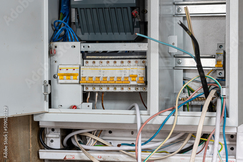 two-tariff electricity meter with electric vending machines in a metal box on the wall inside the house. repair of eletrica in the house photo