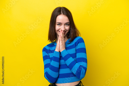 Young Ukrainian woman isolated on yellow background keeps palm together. Person asks for something