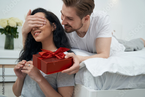 Loving man presenting gift to beloved woman