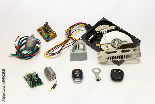 Printed circuit board with a set of chips, cables, connectors, remote controls, for design solutions and electronics elements, vertical photography, on a white milky background.