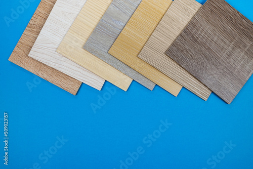Laminate boards on blue. Samples of laminate or parquet with a pattern and texture of wood for flooring and interior design.