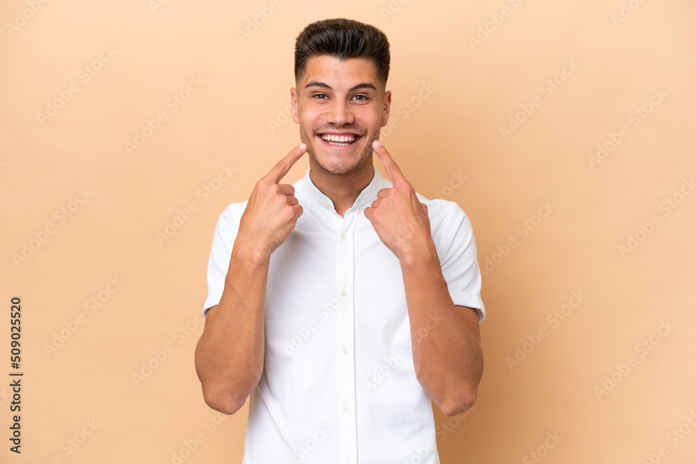 Young caucasian man isolated on beige background smiling with a happy and pleasant expression Young caucasian man isolated on beige background smiling with a happy and pleasant expression