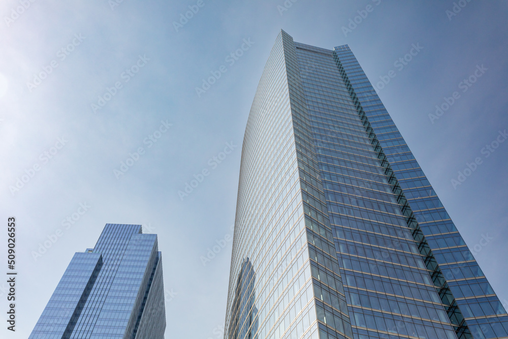 Two modern glass skyscrapers on clear day in urban setting