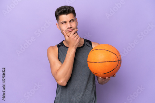 young caucasian woman basketball player man isolated on purple background having doubts