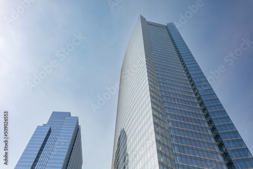 Two modern glass skyscrapers on clear day in urban setting