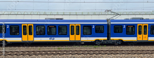 Weesp, the Netherland - June 5, 2022: Side view of a Dutch public transport train standing in a railway station.