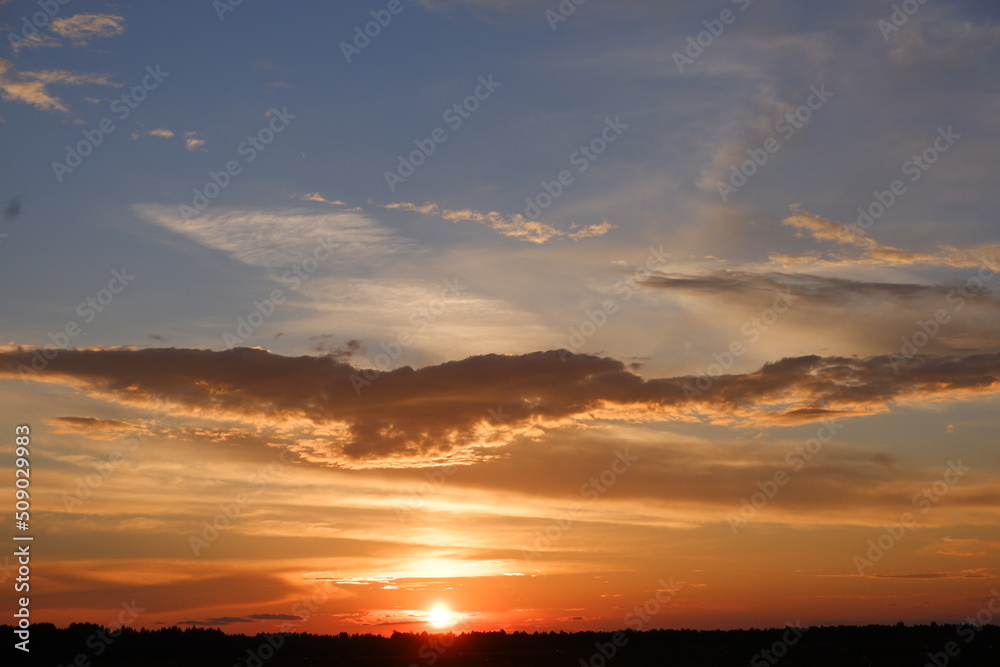 Red sunset landscape. Cumulus red clouds during sunset. Red clouds and blue sky at sunset.