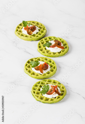 Vegan Spinach waffles with cherry tomatoes and parsley. Light background