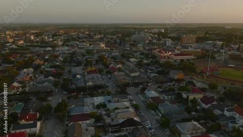Aerial descending footage of buildings in town at dusk. Forwards fly above streets and houses. Port Elisabeth, South Africa