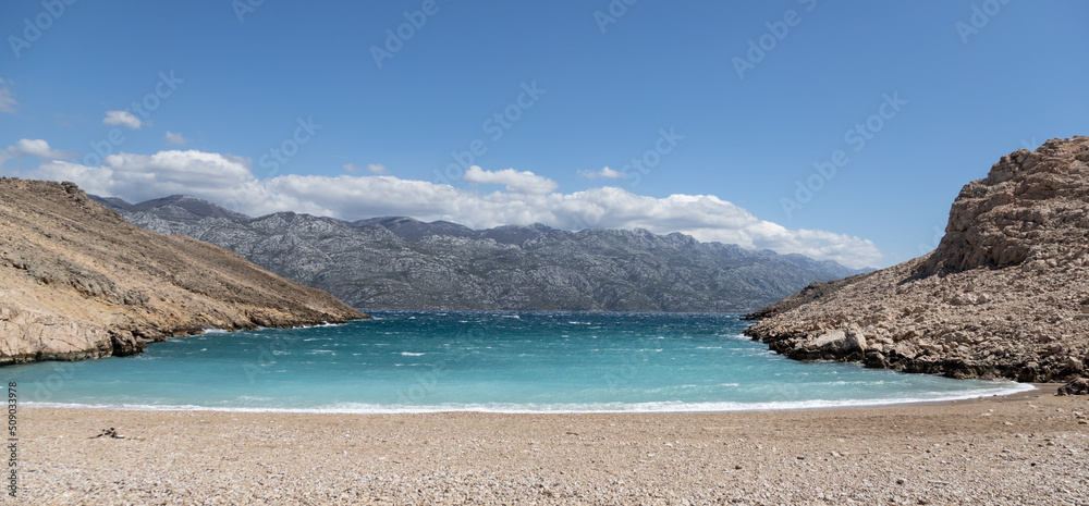 Blue sea and rocky mountains of Croatia in a clear day, velebit mountain in the horizon