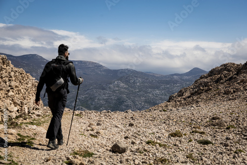 A man walking in a trail in rocky mountains, deserted place