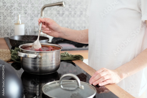 Woman cooking soup in the kitchen