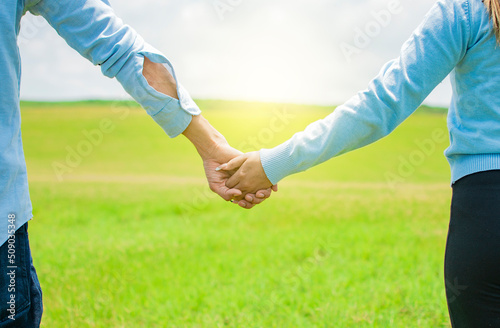 Hands together of a couple in the field, Close up of a couple holding hands, Concept of couple hands holding hands