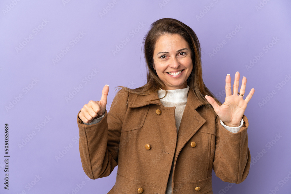 Middle age Brazilian woman isolated on purple background counting six with fingers Middle age Brazilian woman isolated on purple background counting six with fingers