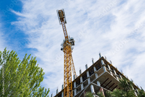A construction crane works on the construction site of a multi-storey building.