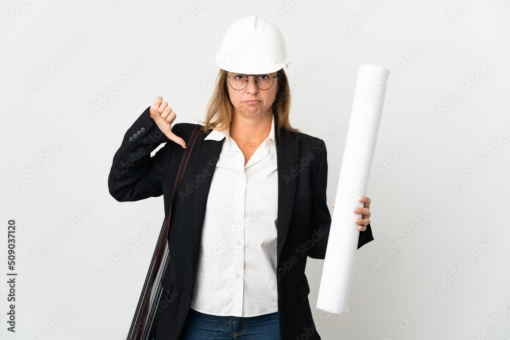 Middle age architect woman with helmet and holding blueprints over isolated background showing thumb down with negative expression Middle age architect woman with helmet and holding blueprints over isolated background showing thumb down with negative expression