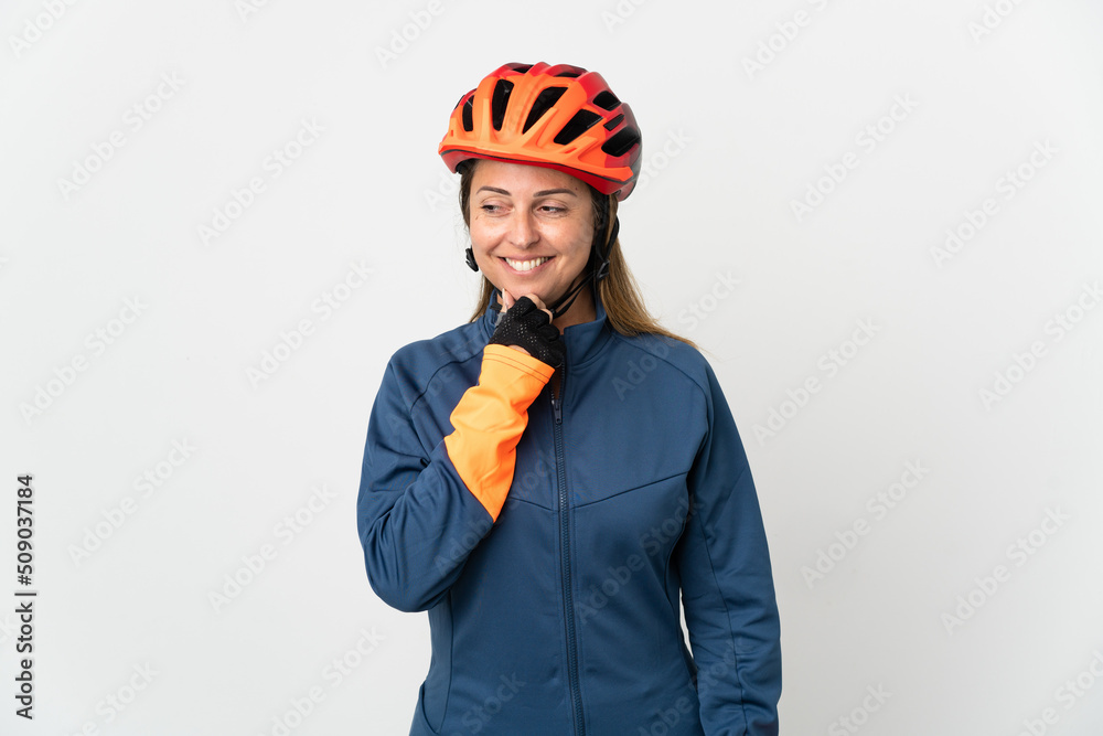 Middle age cyclist woman isolated on white background looking to the side and smiling