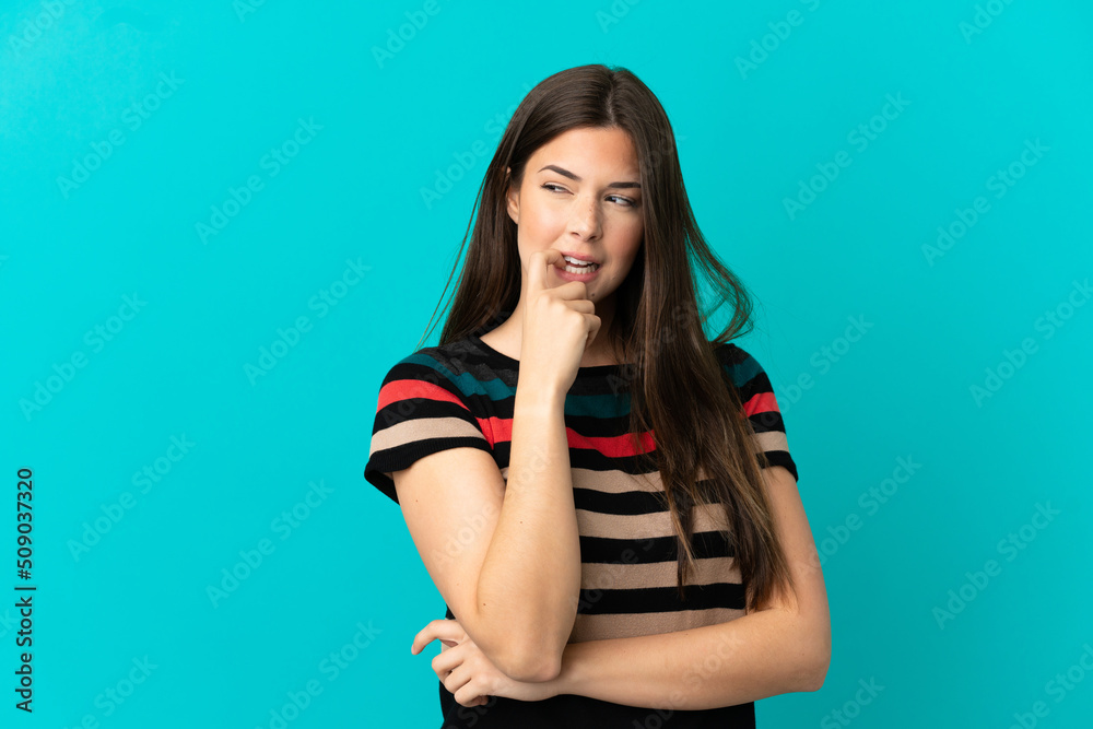 Teenager Brazilian girl over isolated blue background nervous and scared Teenager Brazilian girl over isolated blue background nervous and scared