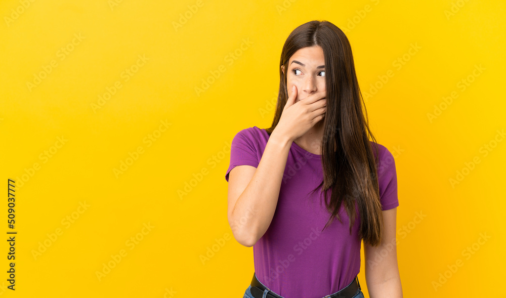 Teenager Brazilian girl over isolated yellow background doing surprise gesture while looking to the side