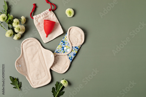 Zero waste periods kit. Eco friendly feminine hygiene, reuse concept. Reusable sanitary pads and menstrual cup for personal hygiene. Waste-free lifestyle. photo