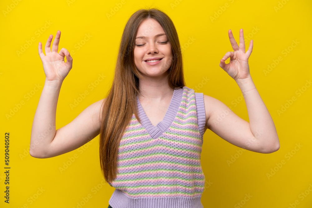 Young caucasian woman isolated on yellow background in zen pose Young caucasian woman isolated on yellow background in zen pose