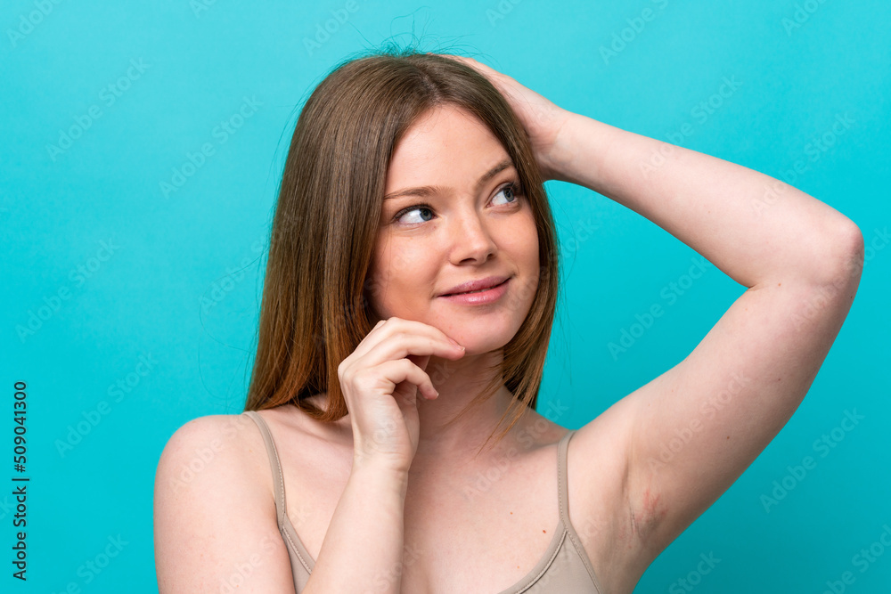 Obraz premium Young caucasian woman isolated on blue background . Portrait