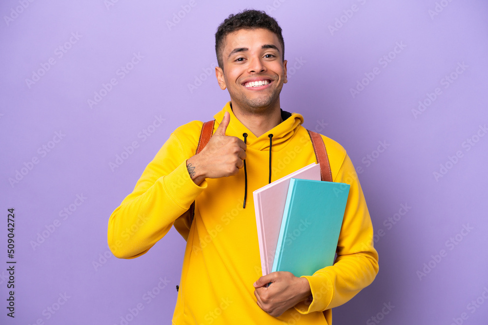 Young student Brazilian man isolated on purple background giving a thumbs up gesture Young student Brazilian man isolated on purple background giving a thumbs up gesture