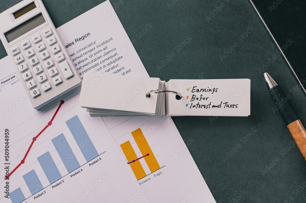 There is word card on the desk about Earnings Before Interest and Taxes. It's placed with dummy documents. There is word card on the desk about Earnings Before Interest and Taxes. It's placed with dummy documents.