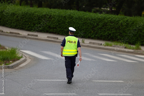 Policjant ruchu drogowego podczas zatrzymania pojazdów na drodze z tarczą do zatrzymywania