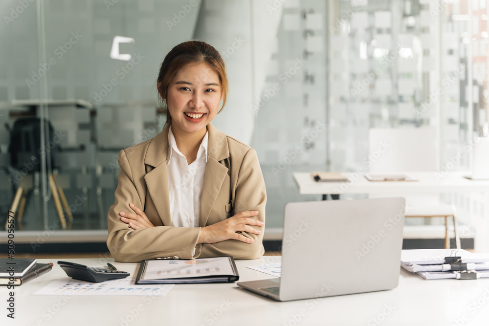 Young beautiful woman using her laptop while sitting in a chair at her working place. Young beautiful woman using her laptop while sitting in a chair at her working place.