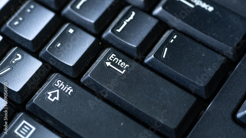 Selective focus on enter key in solid black color keyboard. photo