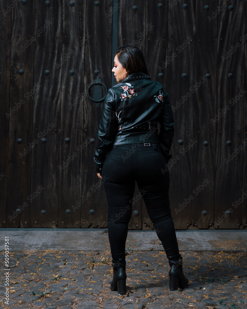 Portrait of young woman in biker jacket.