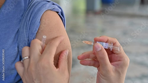 Healthcare worker giving a shot of Influenza vaccine to patient. Influenza vaccines are vaccines that protect against flu. photo