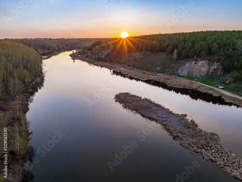 Beauriful sunset view along the Iset river and rocks near Kamensk-Uralskiy. A scenic sunset at the river. Kamensk-Uralskiy, Sverdlovsk region, Ural mountains, Russia. Aerial view photo