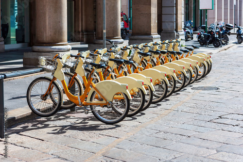 An orange bicycle with a basket for trips around Milan is waiting for cyclists. Bike rental Milan, Italy