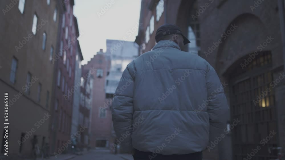 Guy in copenhagen in white jacket, walking down small city street. 60fps Guy in copenhagen in white jacket, walking down small city street. 60fps