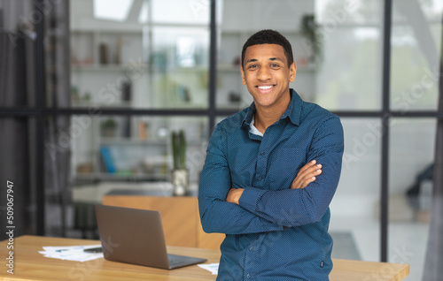 Photography Portrait of successful young african american businessman with arms crossed standing in modern office