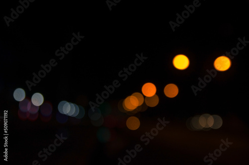 bokeh background with the light of street lamps and car lights at night out of focus © Khanawut