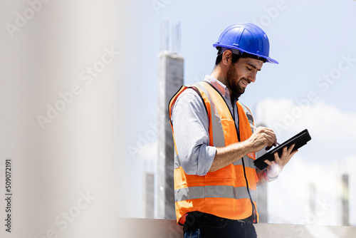 A portrait of an industrial man engineer with smartphone in a factory, working. photo