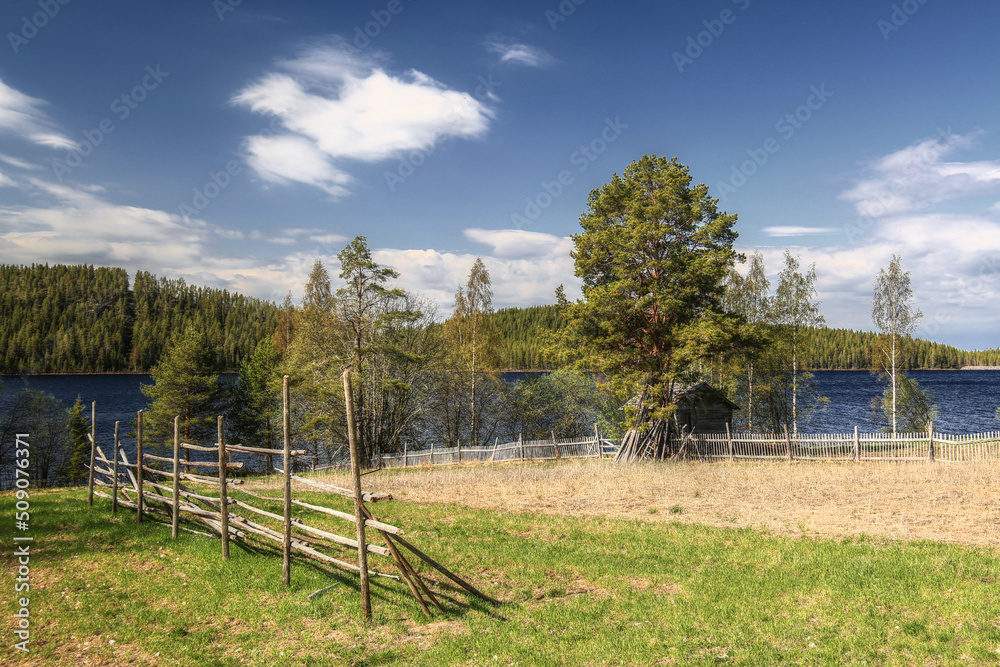 Rural field, fence and shack in the village Gallejaur in northern Sweden