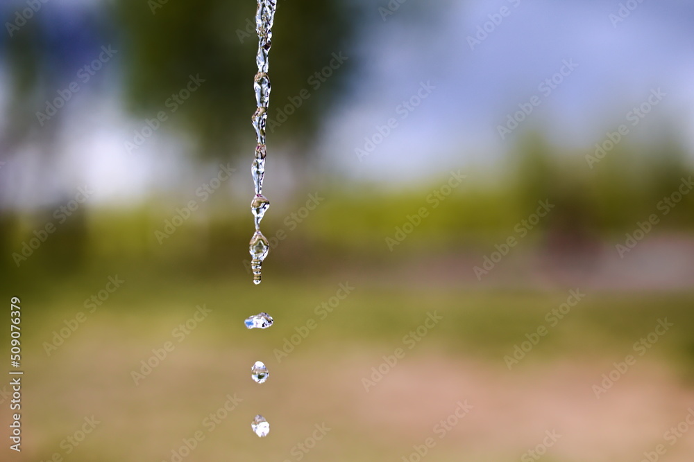 Fresh water drops falling in front of blurred natural background Fresh water drops falling in front of blurred natural background