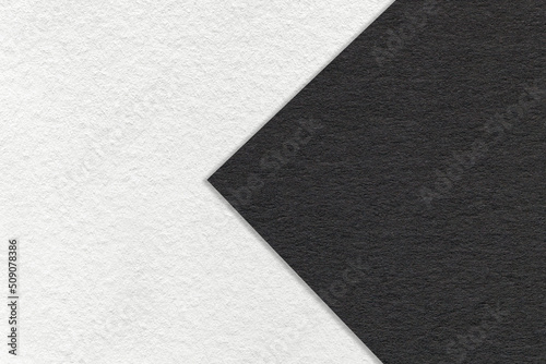 Texture of black and white paper background, half two colors with arrow, macro. Structure of dense craft cardboard.