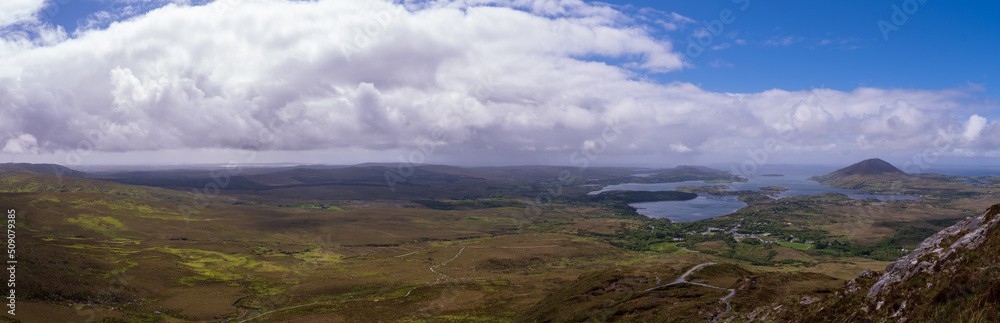 scenic panoramic vista over Connemara National Park with white clouds and blue sky in Spring
