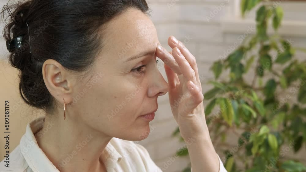 Sinus massage. A woman makes a medical sinus massage by her nose for healthy breathing in the room. Sinus massage. A woman makes a medical sinus massage by her nose for healthy breathing in the room.