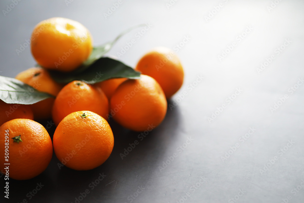 Citrus fruits on a gray background. Tangerines with leaves. Christmas fruit. Citrus fruits on a gray background. Tangerines with leaves. Christmas fruit.