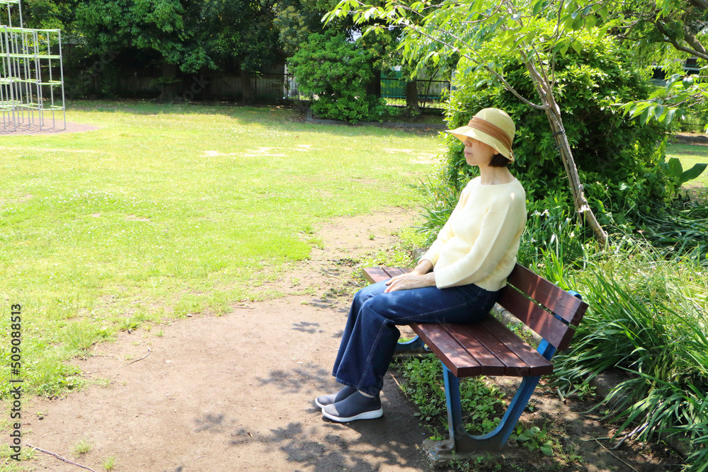 Fototapeta premium 公園のベンチに座る女性