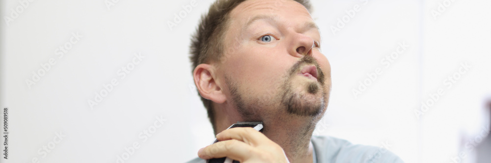 Obraz premium Concentrated guy give form to beard